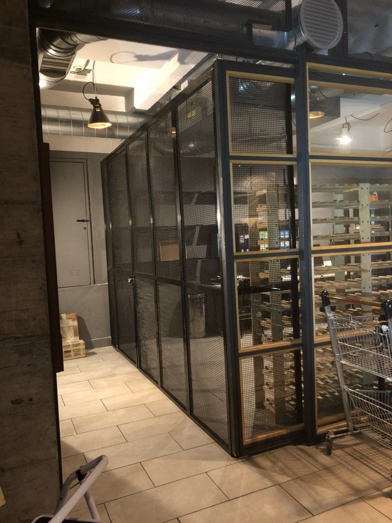 Parete attrezzata in ferro e vetro in un locale commerciale