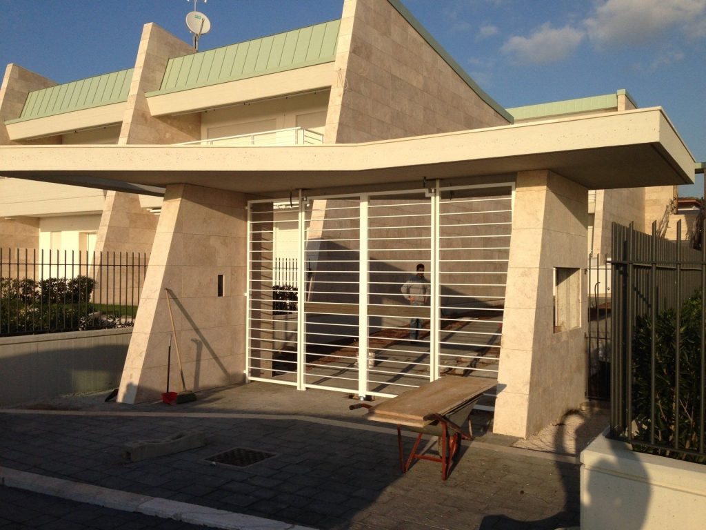 Cancello a correnti bianchi sotto una pensilina d’ingresso
