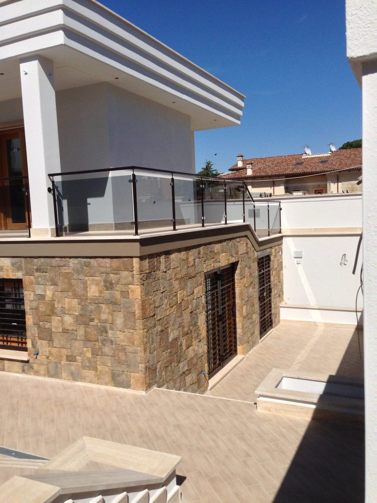 Parapetto in vetro e ferro su terrazzo di una villa in pietra