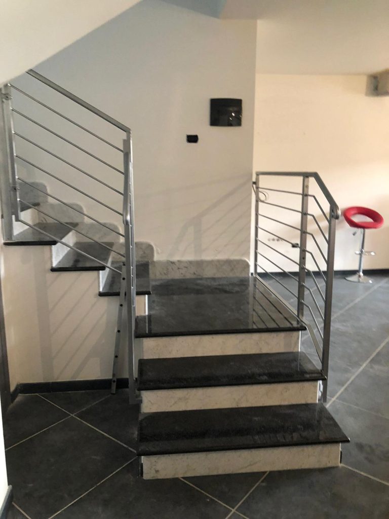 Ringhiera in acciaio su scala con gradini scuri