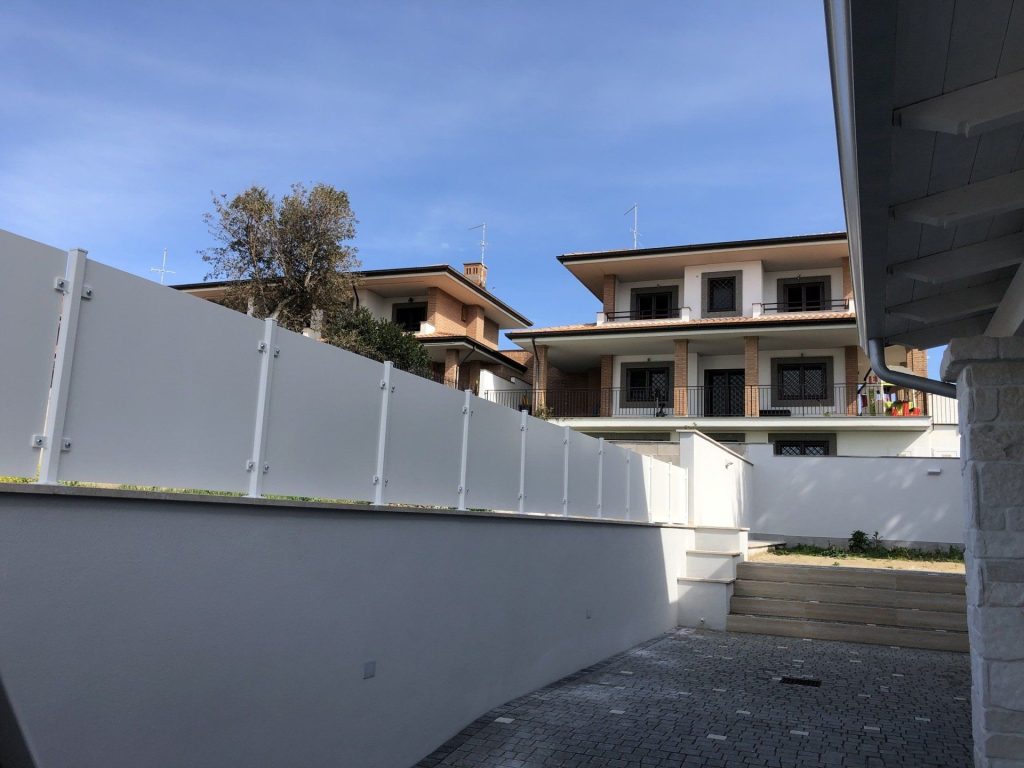 Parapetto a pannelli bianchi su muro di cinta