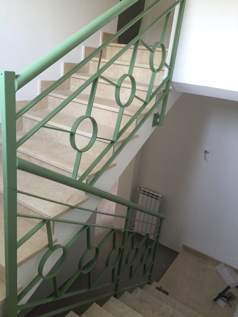 Ringhiera verde a cerchi su scala condominiale