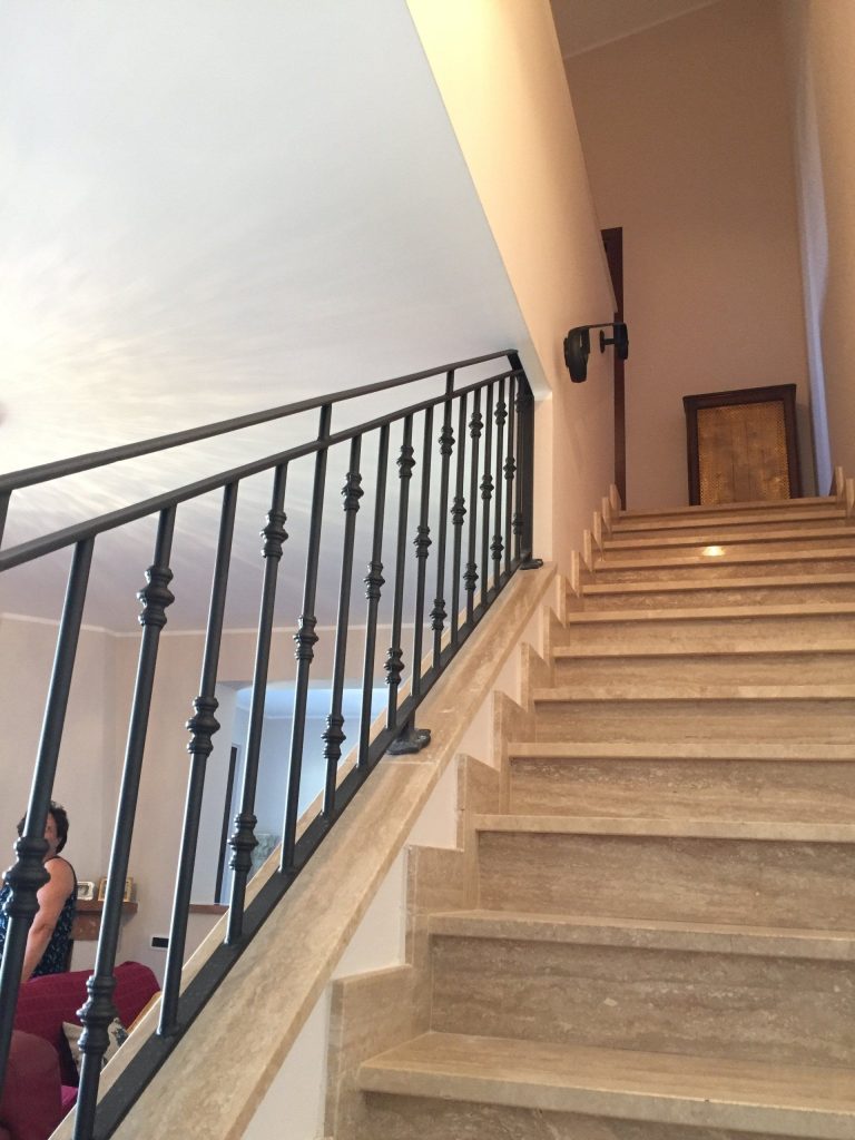 Ringhiera in ferro su scala in travertino