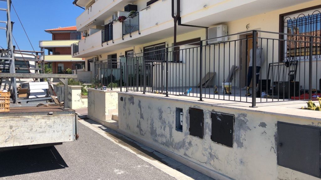 Ringhiera nera su muretto di un condominio